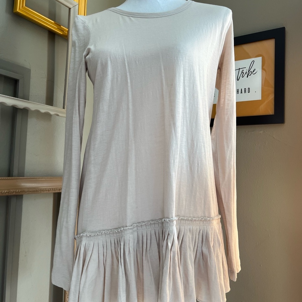 Adorable tunic top by LOGO. Size XS. Cream. Ruffle detail at bottom.